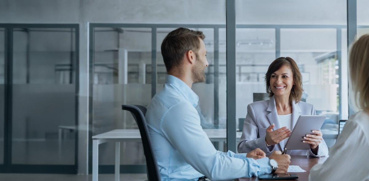 Senior advisor discussing strategy with colleagues around a tablet